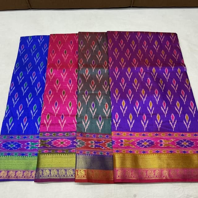 Vibrant shades of pink, purple, teal, green, gold, and red, with patterned elements incorporating multiple colors. Saree